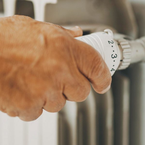 close-up-old-man-hand-closing-heating-home-thermostat-gas-energy-saving-concept-bills-heat-crisis-costs-people-adjusting-radiator-supply-save-money-during-winter close-up-old-man-hand-closing-heating-home-thermostat-gas-energy-saving-concept-bills-heat-crisis-costs-people-adjusting-radiator-supply-save-money-during-winter