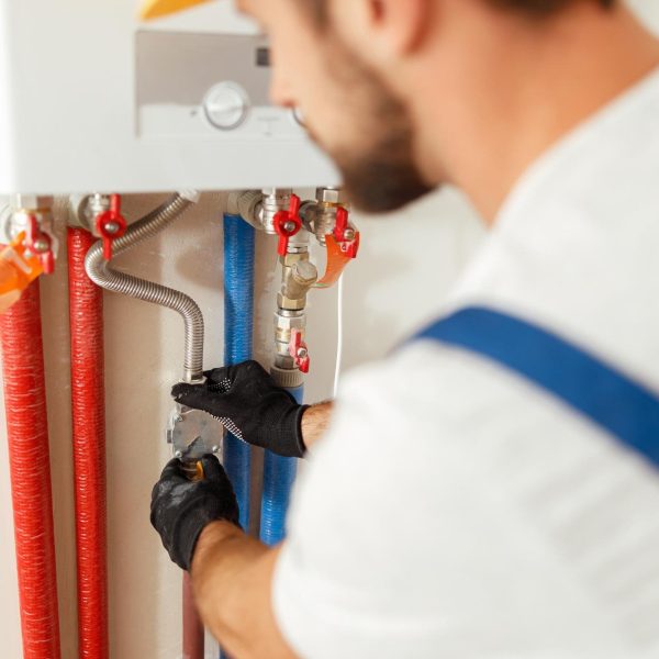 closeup-plumber-working-with-water-pipes-while-installing-heating-system-apartment closeup-plumber-working-with-water-pipes-while-installing-heating-system-apartment