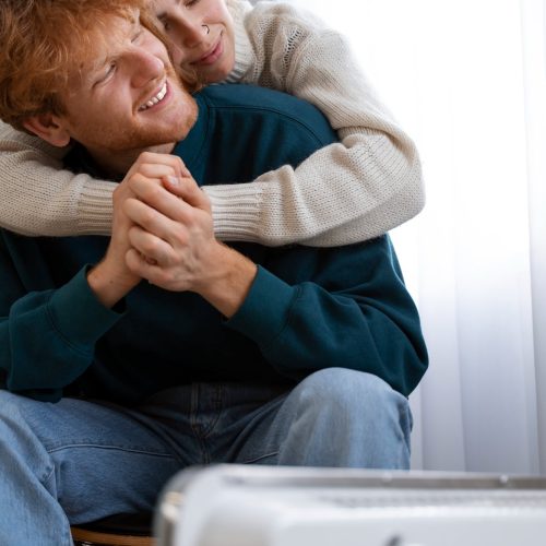 medium-shot-smiley-couple-near-heater medium-shot-smiley-couple-near-heater